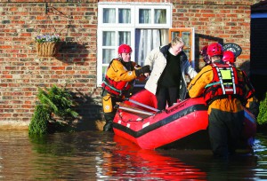 Members of the emergency services rescue a woman from a flooded street in Naburn, northern England, December 27, 2015.    REUTERS/Phil Noble