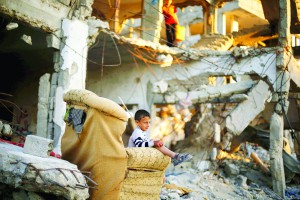 A Palestinian boy sits on a sofa outside his family house that witnesses said was destroyed during the 50-day war last summer, in the east of Gaza City May 4, 2015. Israel inflicted "massive and unprecedented harm" to Palestinian civilians in the 2014 Gaza war with indiscriminate fire and lax rules of engagement, a report said on Monday, citing testimony given anonymously by dozens of troops. REUTERS/Mohammed Salem      TPX IMAGES OF THE DAY