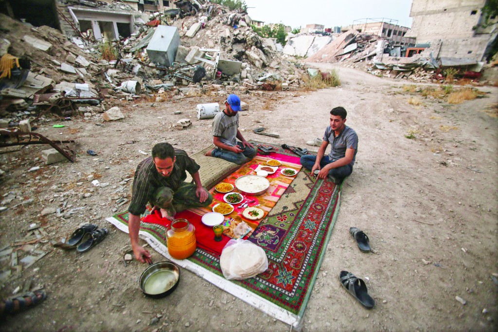 epa05371671 Soldiers of the Free Syrian Army wait for the iftar time to break their fast during the Muslim holy fasting month of Ramadan, in the rebel-held neighborhood of Jobar, Damascus, Syria, 16 June 2016. Muslims around the world celebrate the holy month of Ramadan by praying during the night time and abstaining from eating and drinking during the period between sunrise and sunset. Ramadan is the ninth month in the Islamic calendar and it is believed that the Koran's first verse was revealed during its last 10 nights. EPA/MOHAMMED BADRA